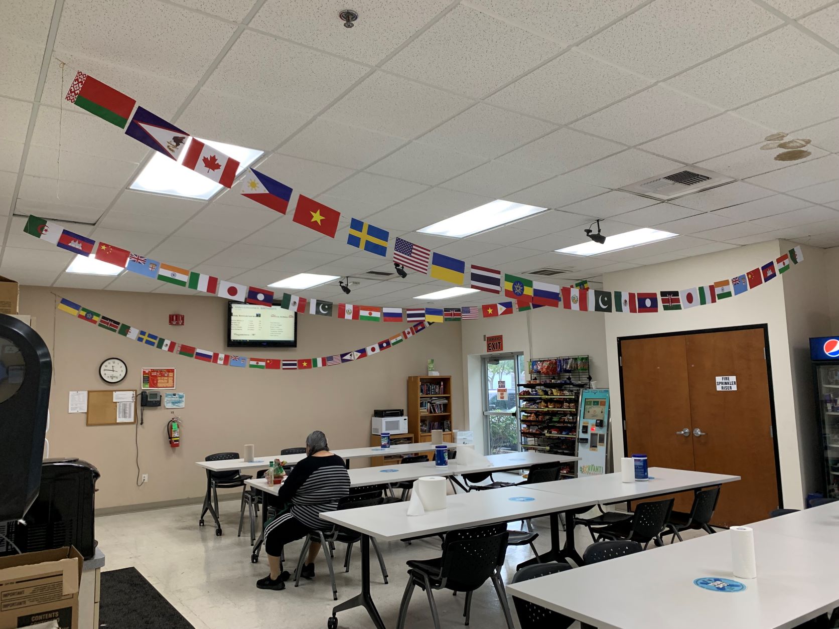 Strings of flags representing employee nationalities are hung from the ceiling of the Sacramento breakroom